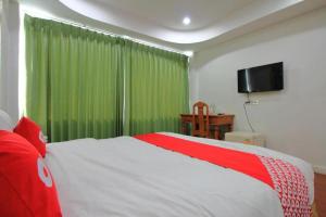 a bedroom with a large bed with a green curtain at Diamond Sweet Hotel in Bangkok