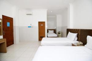 a hotel room with two beds and a bathroom at Metro Hotel in Surabaya +96 photos