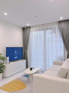 a living room with a white couch and a tv at Relax Homestay 6 in Kon Rung (1)