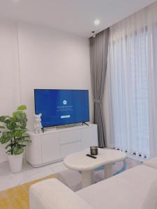 a living room with a tv and a table at Relax Homestay 6 in Kon Rung (1) +5 photos