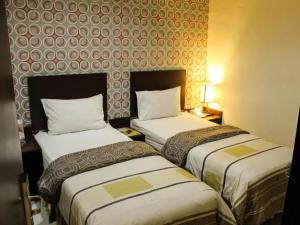 a hotel room with two beds and a wall at Vindhika Hotel in Makassar +43 photos