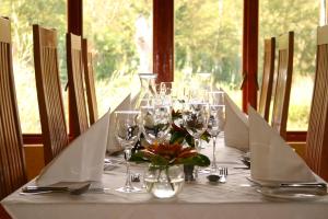 a table with wine glasses and flowers on it at Woodall Country House and Spa in Addo