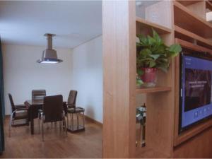 Un comedor con mesa y sillas y un televisor. en James Joyce Coffetel Changsha Wanjiali Baoqiaobei Metro Station, en Changsha