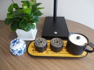 a table with a tray with three cups and a coffee pot at Fairyland Hotel Kunming Tuodong Branch in Kunming