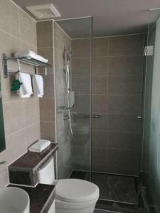 a bathroom with a shower with a toilet and a sink at Jinjiang Inn Style Ningxia Guyuan Beijing Road in Guyuan