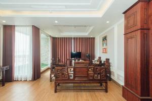 a living room with a table and chairs and a television at Hung Long Hotel in Bắc Ninh