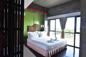 a bedroom with a large bed and a green wall at Ps Extra Hotel in Hat Yai