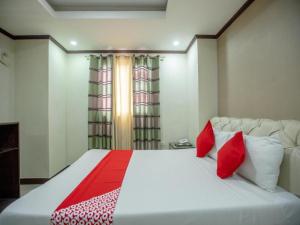 a bedroom with a large white bed with red pillows at OYO 700 Pj Inn Hotel in Angeles +78 photos