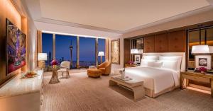 a bedroom with a large bed and a living room at Wynn Macau Hotel in Macau +131 photos