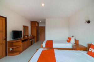 Una habitación de hotel con dos camas y un televisor. en OYO 794 Nice Mum Lodge, en Chiang Mai