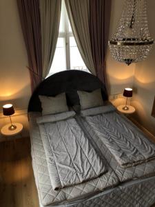 a bed in a bedroom with a chandelier at Ebbas vandrarhem in Borgholm