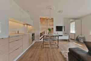 a kitchen with a table and a living room at Dream Apartments- Sopot Avenue in Sopot