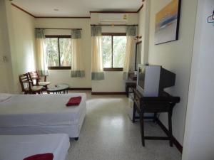 チャウエンにあるJinta Hotel Nathon Beachのベッドルーム1室(ベッド2台、テレビ、デスク付)