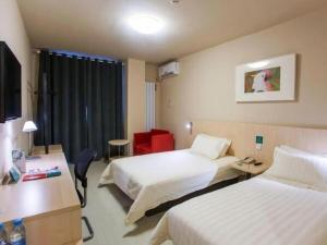 a hotel room with two beds and a desk at Jinjiang Inn Pingyao Branch in Pingyao +91 photos