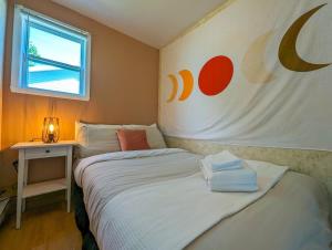 a bedroom with two beds and a table with a window at Chalet #2 Waterfront with Spa Fireplace Wifi & AC in Cap-Saint-Ignace