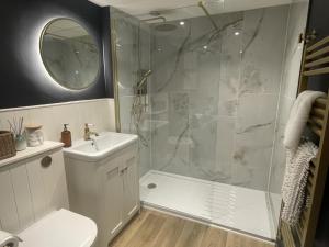 a bathroom with a shower and a toilet and a sink at Wisteria Cottage - 2 bed near Bath & many NT sites in Holt +37 photos