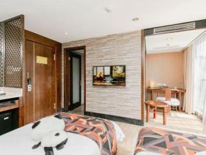 a bedroom with a large bed and a living room at Chengdu Nine Point Art Hotel in Chengdu