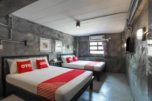 a bedroom with two beds with red pillows at Vm1 Hostel in Bangkok