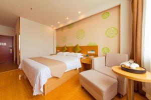 a bedroom with a bed and a table and a chair at GreenTree Inn Tangshan Xueyuan Road Business Hotel in Tangshan +208 photos