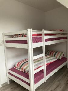 two white bunk beds in a room at Ostfrieslandsuite in Aurich