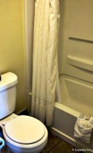 Un baño con inodoro y cortina de ducha. en Lemon Heights Inn, en Tustin 26 fotos más
