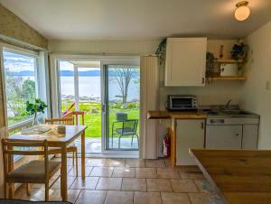 a kitchen with a table and a kitchen with a view at Chalet Studio #3 Waterfront with Spa Fireplace & Wifi in Cap-Saint-Ignace