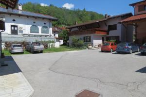 a parking lot in front of a house with cars parked at Apartments Masera in Kobarid