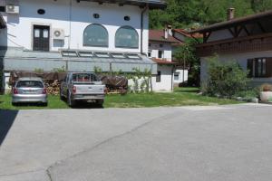 two cars parked in front of a house at Apartments Masera in Kobarid
