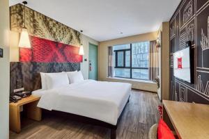 西安ibis Xian South Gate的酒店房间里有一张白色的大床和一张书桌