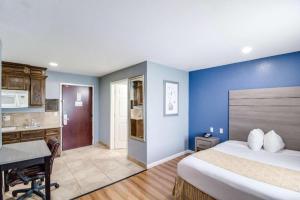 a bedroom with a bed and a desk in a room at Rodeway Inn & Suites Port Arthur - Groves in Port Arthur