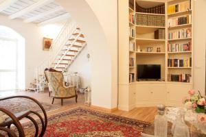uma sala de estar com uma escada e uma televisão em A Casa della Nonna em Cefalù