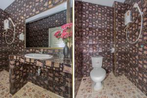 a bathroom with a toilet and a sink and a mirror at OYO 650 At Night Pranburi in Hua Hin