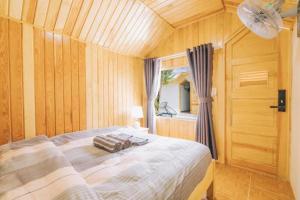 a bedroom with a large bed in a wooden room at Da Lat Cam Ly Hotel in Ấp Kim Thạch +107 photos