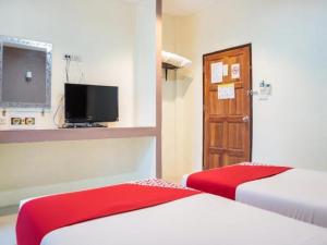 une chambre d'hôtel avec deux lits et une télévision dans l'établissement OYO 902 Life and Love Resort, à Ban Khlong Haeng
