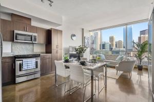 カルガリーにあるThe Prime Downtown | Luxe Condo + Free Parkingのキッチン(テーブル、椅子付)、リビングルーム