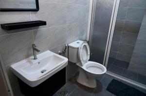 Un baño con un inodoro blanco y un lavabo. en CK Home, en Ipoh 12 fotos más
