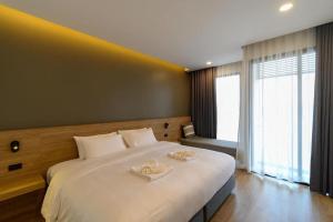 ein Schlafzimmer mit einem großen Bett mit zwei Handtüchern darauf in der Unterkunft Chewa Khong Hotel Nakhon Phanom in Ban Tha Khwai + 123 Fotos