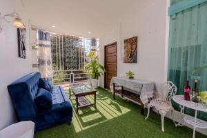 a living room with a blue couch and a table at Dao Residence Boutique in Ban Phôn Khéng