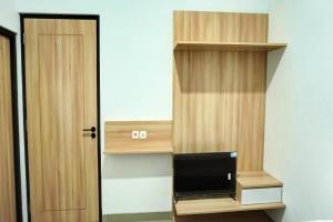 a room with a book shelf with a television in it at Capital O 92804 La Tansa Syariah Hotel in Bekasi +18 photos