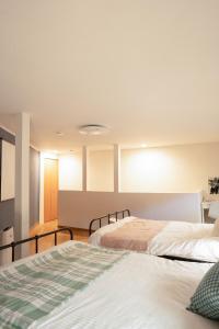 two beds in a room with two beds sidx sidx sidx sidx at AsashiobashiBase in Osaka