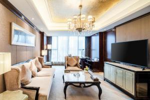 a living room with a couch and a flat screen tv at Chengdu Rising Butterfly Hotel in Chengdu