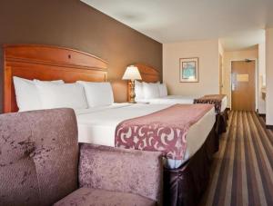 a hotel room with a large bed and two chairs at Best Western Manhattan Inn in Manhattan +111 photos