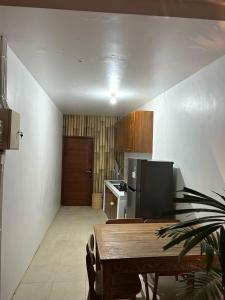 a kitchen with a wooden table and a refrigerator at Tri Putri Villa in Badung