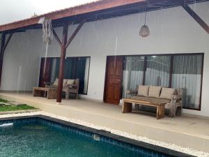 a patio with a couch and a table next to a pool at Tri Putri Villa in Badung