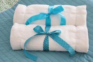 a stack of towels with blue bows on a bed at Apartment in Center in Kraków