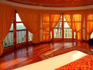 a living room with orange curtains and a rug at The Hideaway Hotel in Ella +55 photos