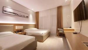 a hotel room with two beds and a television at Avenue Suites in Bacolod