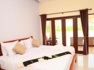 a bedroom with a bed with white sheets and a window at Juntima Boutique Hotel in Ban Rong Rakam +53 photos