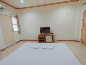 a bedroom with a large bed and a tv at Sabai Hotel Korat in Ban Khok Phai (1)