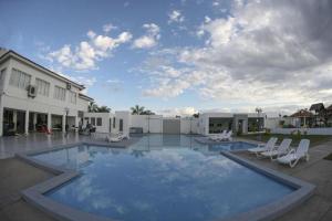 Una gran piscina con sillas y un edificio. en Terranova Suites, en Santa Cruz de la Sierra